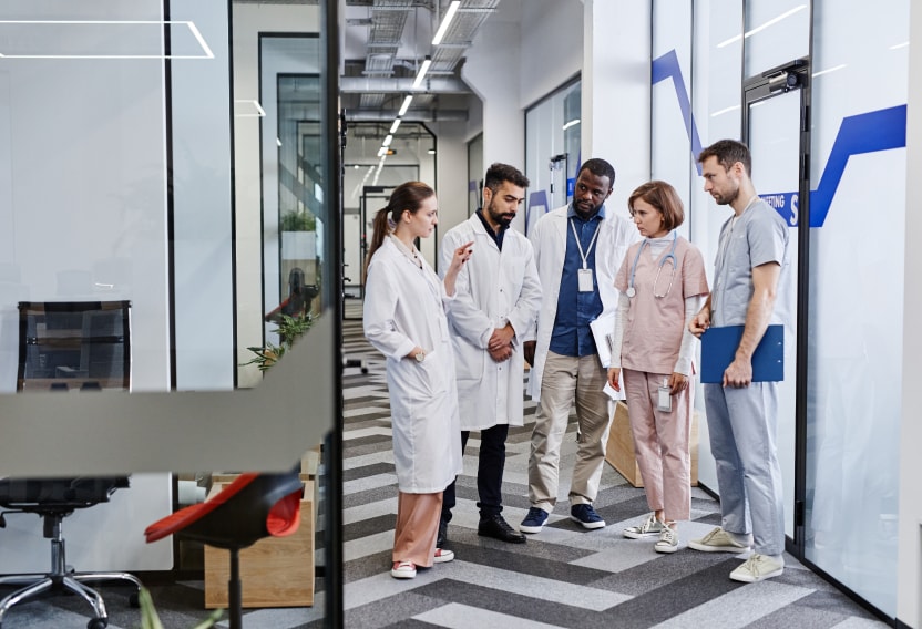 Allied health professionals engage in conversation in a bustling hallway, representing the dynamic nature of allied health travel jobs and collaboration within the healthcare industry.